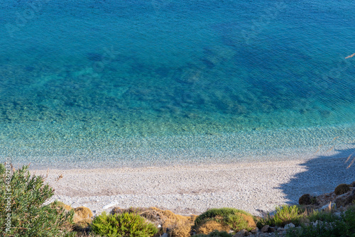 Fototapeta Naklejka Na Ścianę i Meble -  Turquoise clear blue water on a small beach in Ikaria, Greek Aegean Sea