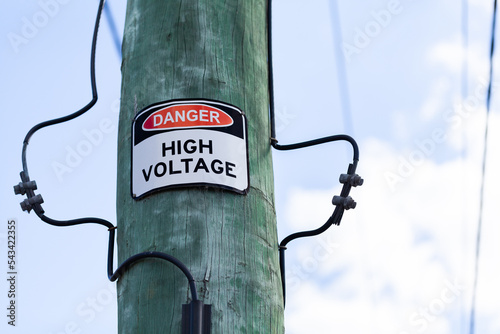 Danger warning high voltage sign on power pole photo