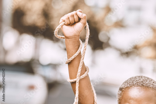 Tela Hand, rope and fist protest slavery for freedom and human rights against an urban background