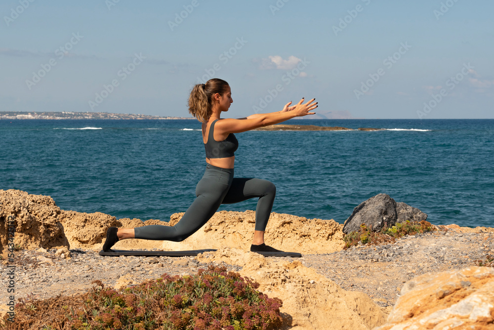 Malia, Crete, Greece. 2022. Pilates exercises on the beach in Crete. The Lungee position Malia, Crete, Greece. 2022. Pilates exercises on the beach in Crete. The Lungee position