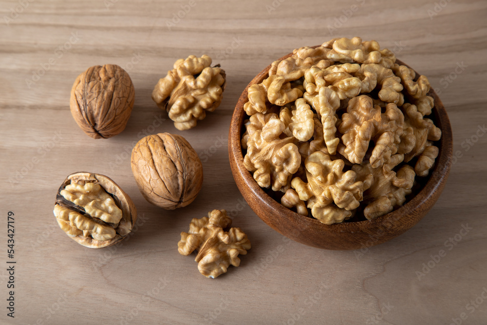Peeled walnuts and whole walnuts in wooden bowl
Peeled walnuts and whole walnuts in wooden bowl