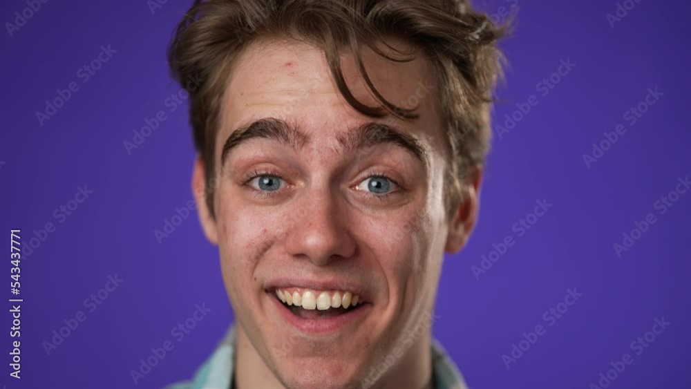 Slow motion closeup portrait of laughing smiling, happy, handsome young hipster man 20s isolated on purple color background in studio. Sincere emotions lifestyle concept. Slow motion closeup portrait of laughing smiling, happy, handsome young hipster man 20s isolated on purple color background in studio. Sincere emotions lifestyle concept.