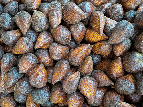 collection of brown salak pondoh fruits scaly like sweet snakes some fruits put on wooden table on natural background for sale in fruit shop photo