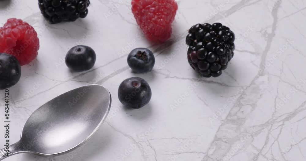 Close up of blueberries and raspberries with cream in bowl Close up of blueberries and raspberries with cream in bowl