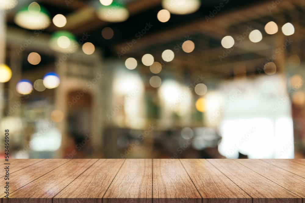 Empty wooden table top with lights bokeh on blur restaurant background. Empty wooden table top with lights bokeh on blur restaurant background.