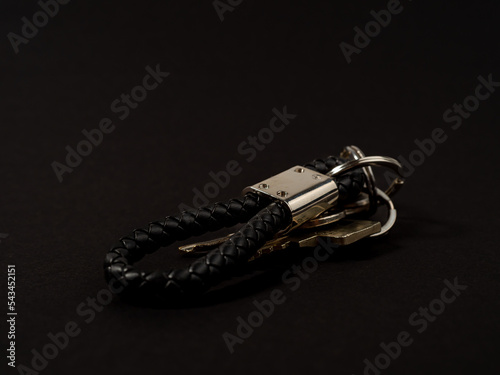 House key with a keychain on a black background.