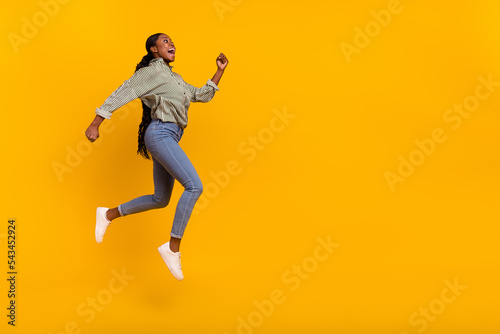 Full body profile portrait of sportive amazed girl look empty space running isolated on yellow color background