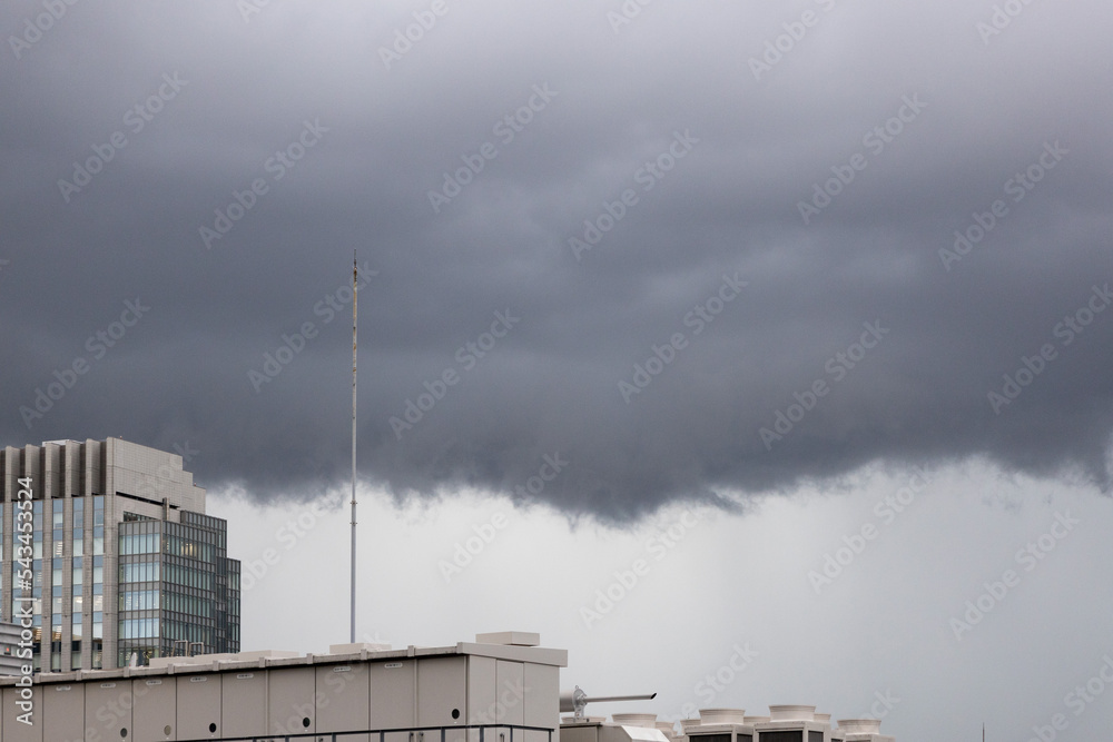 Obraz premium 都会の秋の空・竜巻が発生しそうな嵐の雨雲が広がる空と避雷針と都会のビル（東京都千代田区）