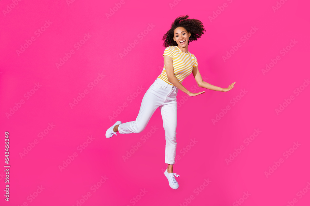 Full length photo of cute young woman dancer jumper excited sales wear trendy yellow striped look isolated on vibrant pink color background