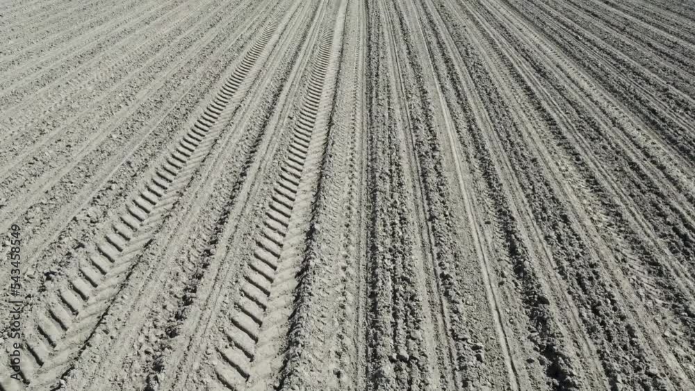 Perfect lines of brown plowed field vertical top view. Smooth stripes on a dirt field Drone view. Arable land flying at low altitude. Plowed field in Belgium aerial view. High quality 4k footage Perfect lines of brown plowed field vertical top view. Smooth stripes on a dirt field Drone view. Arable land flying at low altitude. Plowed field in Belgium aerial view. High quality 4k footage