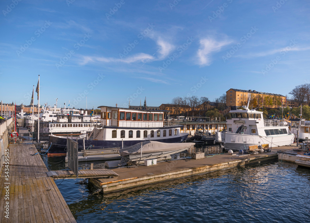 Naklejka premium Moored old commuting ferries in the harbor a sunny autumn day in Stockholm