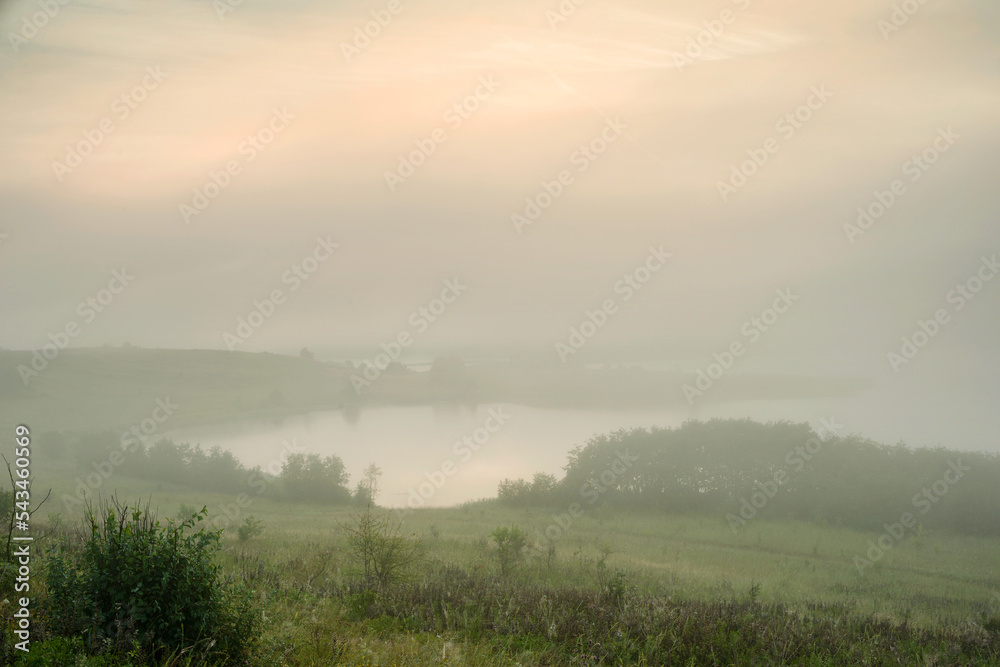 Serene landscape with a lake in the fog Serene landscape with a lake in the fog