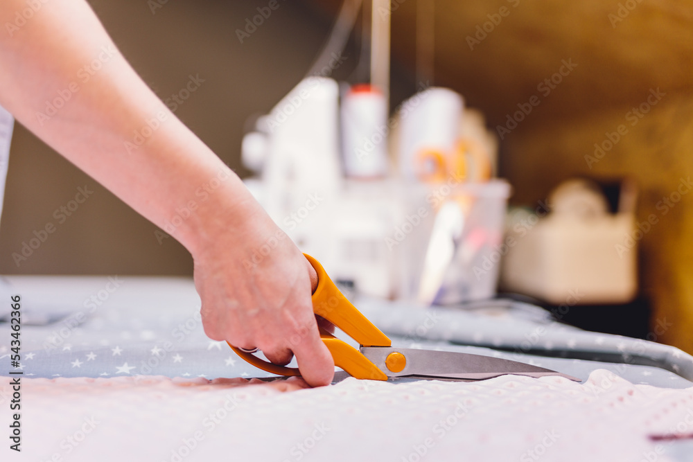 Seamstress dressmaker cutting fabric in clothes sewing workshop Seamstress dressmaker cutting fabric in clothes sewing workshop