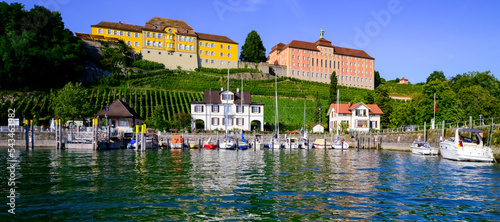 Meersburg harbour panorama on the northern shore of Lake Constance Germany. Colorful buildings, vine yards and boats on a summer day. Historic old town is major tourist and vacaction destination.  photo