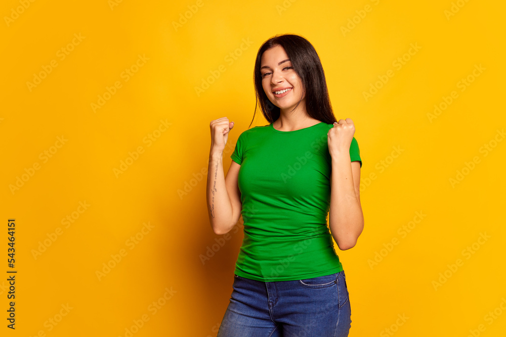 Surprise. Winning success happy woman celebrating being a winner. Image of caucasian female model on studio background. Victory, delight concept. Human facial emotions concept. Surprise. Winning success happy woman celebrating being a winner. Image of caucasian female model on studio background. Victory, delight concept. Human facial emotions concept.