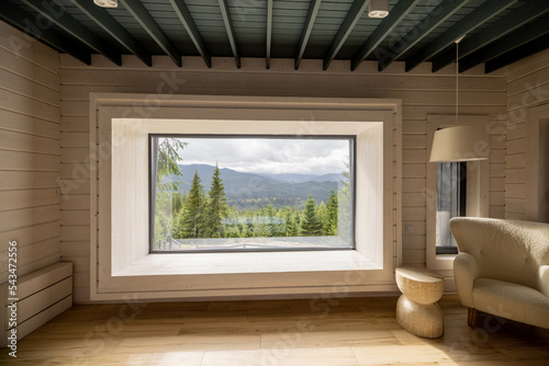 Wooden house interior with panoramic window and scenic view on the mountains