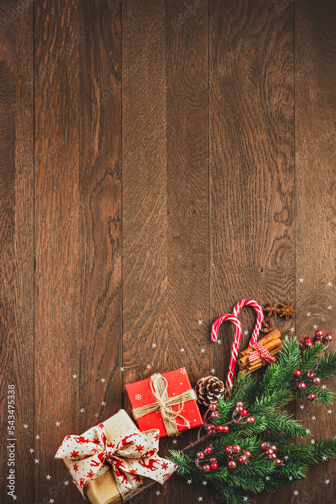Merry Christmas and Happy New Year. Gifts, fir branches and candies on a wooden background