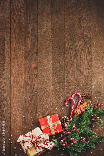 Obraz na płótnie Merry Christmas and Happy New Year. Gifts, fir branches and candies on a wooden background w salonie