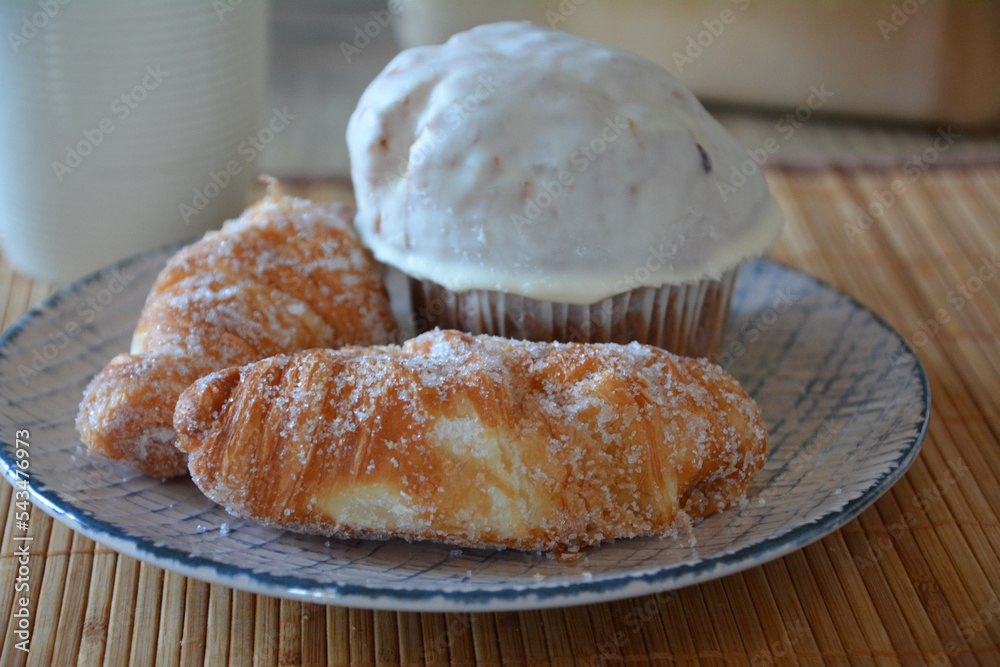Homemade croissants and muffin decorated with white chocolate. Sweet breakfast.