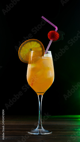 A tropical orange cocktail in a glass is on the table.