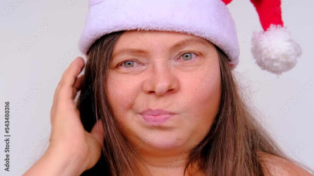 close-up of cheerful adult woman in santa claus red hat with long hair, having fun, festive mood, congratulations, good wishes, christmas concept, waiting for gifts, new year celebration close-up of cheerful adult woman in santa claus red hat with long hair, having fun, festive mood, congratulations, good wishes, christmas concept, waiting for gifts, new year celebration