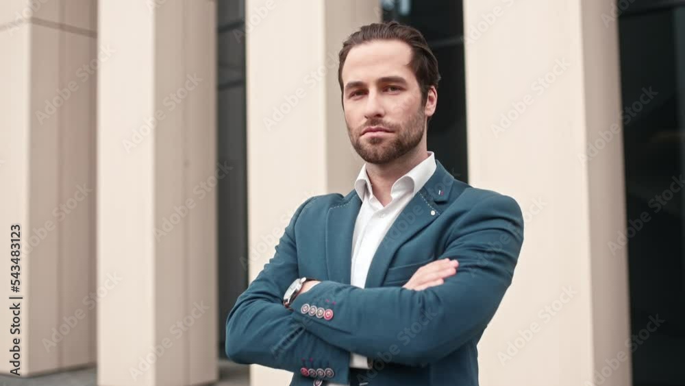 Young successful businessman wearing formal smart clothes posing looking at camera. Wealthy trust-worthy handsome busy male staying outside of office with crossed arms. Businessman concept. Young successful businessman wearing formal smart clothes posing looking at camera. Wealthy trust-worthy handsome busy male staying outside of office with crossed arms. Businessman concept.