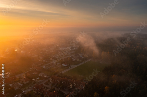 Morning fog over the forest and buildings in northern Poland photo