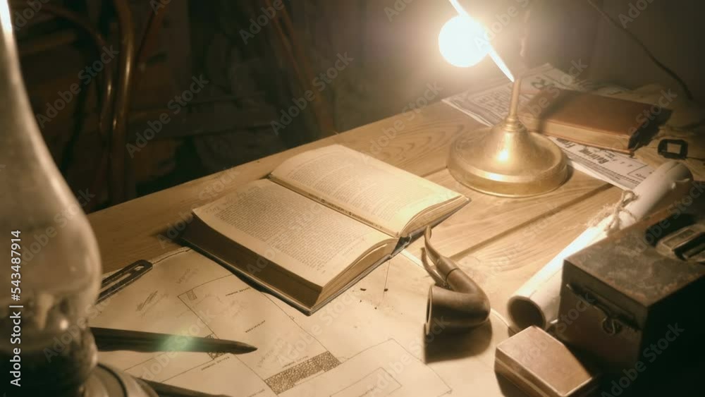 In the twilight, the table of an ancient archaeologist, explorer, adventurer hunter on which a printing press, plans, maps, a magnifying glass, a caliper, a smoking pipe, a kerosene lamp, a notepad
