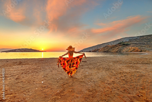 Canvas Print Young woman looking the sunrise from Livadi beach in Folegandros, Greece