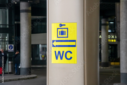 Yellow toilet sign on a pole closeup