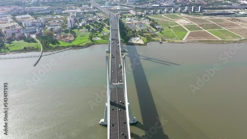 Sensational cinematic aerial view of Vasco da Gama Bridge. Is a cable-stayed bridge flanked by viaducts that spans the Tagus River in Lisbon. It is the second longest bridge in Europe. Drone forward. photo