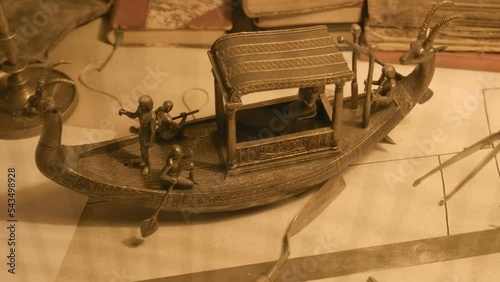 Brass model of an ancient Egyptian boat on the table of an archaeologist found during excavations. Shot in motion. Closeup photo