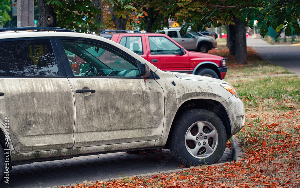 Dirty white car side view. dirty exterior door handle. Texture of mud on white car. Dirty SUV car parked on public parking lot after riding on muddy road. Dirty white car side view. dirty exterior door handle. Texture of mud on white car. Dirty SUV car parked on public parking lot after riding on muddy road.