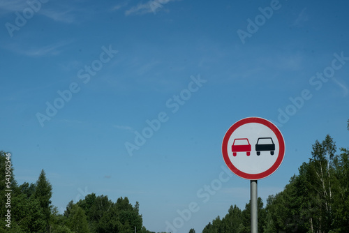 Forbidding road sign "No overtaking" Information about the danger. Summer. Day.