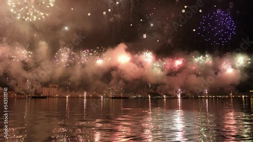 Colorful fireworks burst in air reflecting on water surface in Venice. Traditional firework show at Feast of Redeemer on summer evening