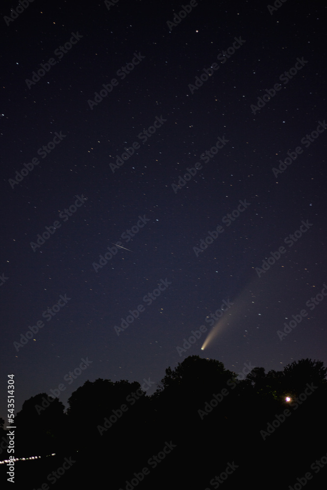 landscape of the night sky, a comet neowise flies over the earth