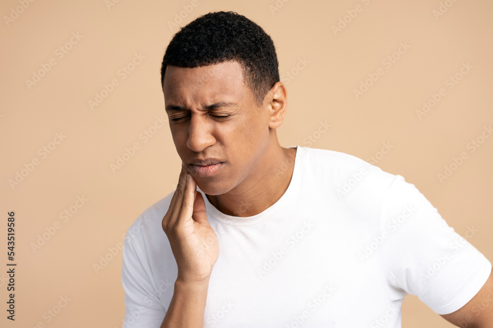 Portrait of unhealthy man pressing sore cheek, suffering acute toothache, periodontal disease Portrait of unhealthy man pressing sore cheek, suffering acute toothache, periodontal disease