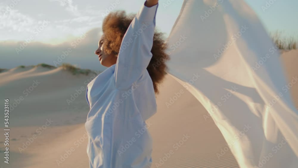 Girl fabric blowing wind at summer desert. Woman posing with white cloth at sand