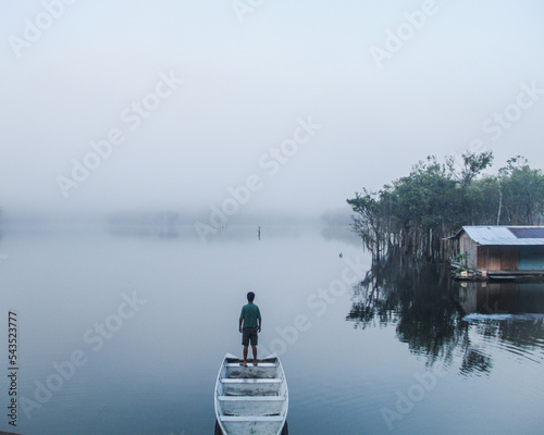 Silhueta de homem não identificado na beira do rio ao amanhecer com neblina em rio preto da Eva, Amazonas photo