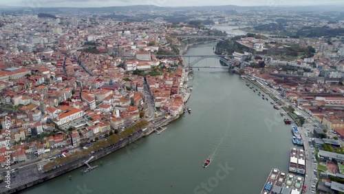 Porto - Portugal, beautiful aerial perspective of city center and River Douro. The second largest city of Portugal and an important travel destination. Cloudy sky. Drone backward and tilt down. photo