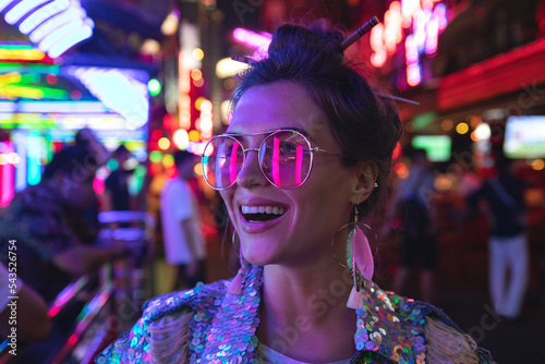 Photography Stylish woman wearing jacket with shining sequins on the city street with neon l