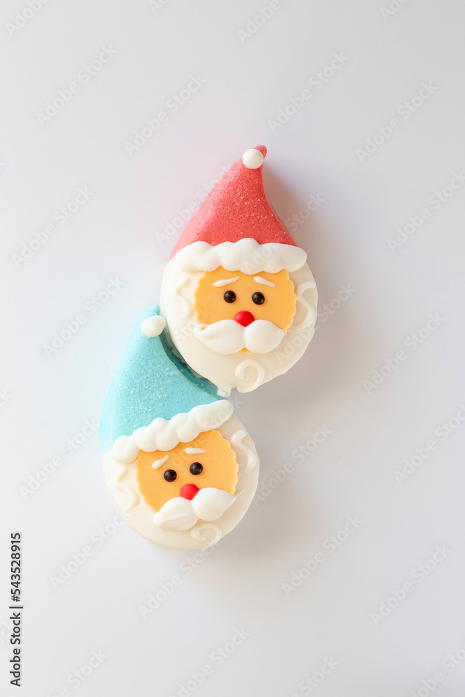two sweet dessert in the form of a Santa Claus head, with a red and blue cap two sweet dessert in the form of a Santa Claus head, with a red and blue cap