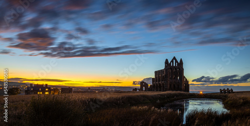 Sunset view of Whitby abbey overlooking the North Sea on the East Cliff above Whitby in North Yorkshire, England photo