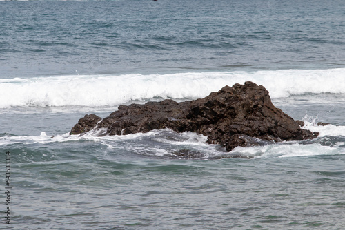 View of Wediombo Beach, Yogyakarta, Indonesia with a row of corals breaking the waves © FawwazMedia