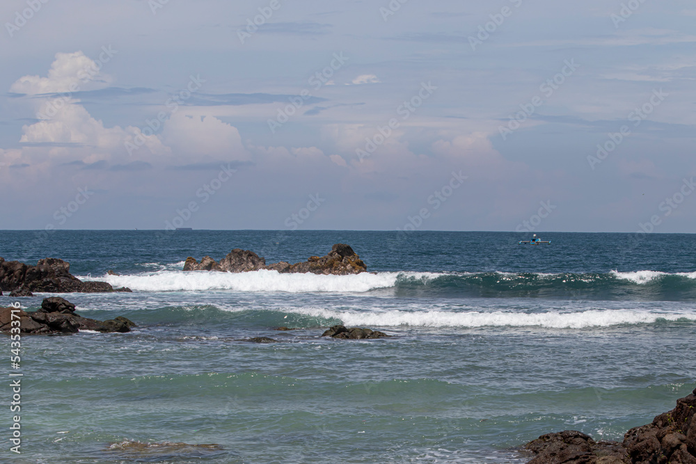 View of Wediombo Beach, Yogyakarta, Indonesia with a row of corals breaking the waves