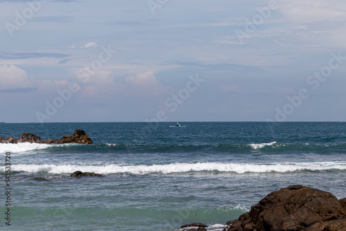 View of Wediombo Beach, Yogyakarta, Indonesia with a row of corals breaking the waves photo