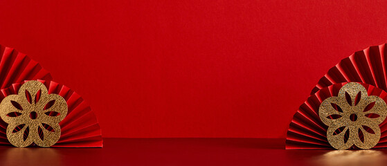Red paper fans with gold flowers on red background. Chinese New Year banner design.