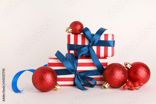 Wallpaper greeting card Merry Christmas holiday composition with blue striped gift box red present toy ball decoration on white background. Xmas New Year winter design idea concept. 