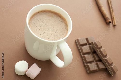 Top closeup of a delicious hot chocolate drink in a mug chocolate candy, marshmallows around