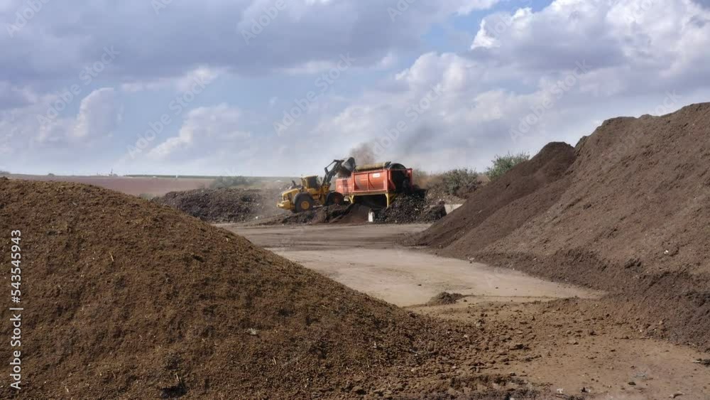 Aerial shot of an Industrial compost production site. Tractors loading compost into machines and trucks Aerial shot of an Industrial compost production site. Tractors loading compost into machines and trucks